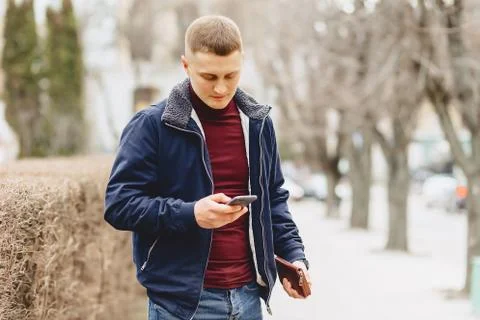 Guy in jacket simple stands with phone Stock Photos
