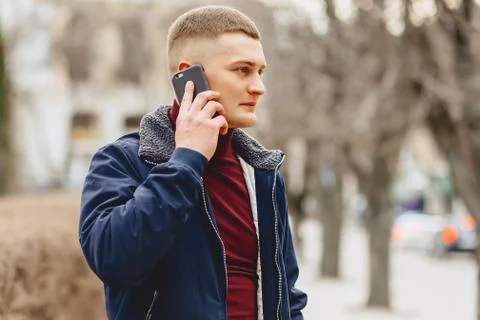 Guy in jacket simple stands with phone Stock Photos