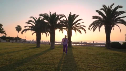 A guy jogging in a trendy 80s suit in purplish pink Stock Footage 139097943