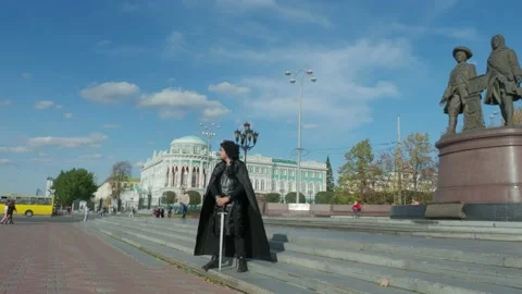 The guy in the Jon snow suit stands in middle of city. Game of Thrones Theme Vídeo Stock 130946432