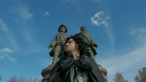 The guy in the Jon snow suit stands in middle of city. Game of Thrones Theme Vídeo Stock 130946437