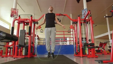 A guy is jumping over a rope in the gym Stock Footage 73988941