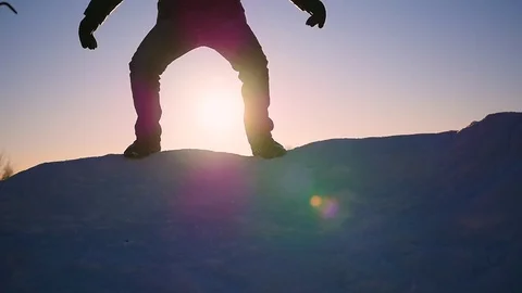 The guy is jumping on a snow slope and raises his hands up at sunset.snow winter 库存影片 71900917