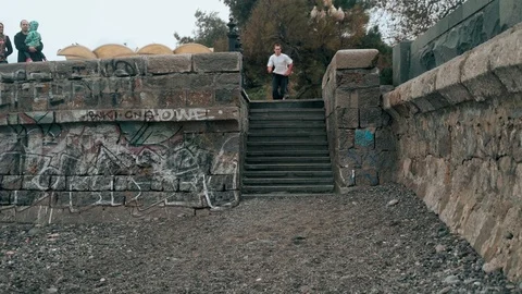 The guy jumps all the steps in the city near the sea. The guy is training Video stock 120423636