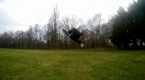 Guy jumps backflip in the park, slowmotion Video stock 48422641