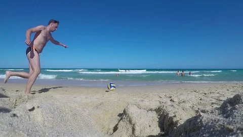 Guy kicking ball at beach in slow motion 動画素材 88601376