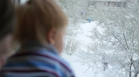 The guy with the kid looking out the window at the snowfall Video stock 68838463