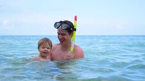 A guy with kid plays having fun in the sea.Snorkelling Video stock 75759415