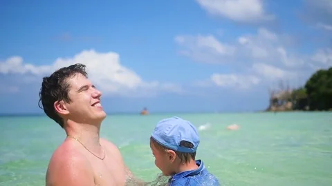 A guy with kid plays having fun in the sea 스톡 동영상 75934419