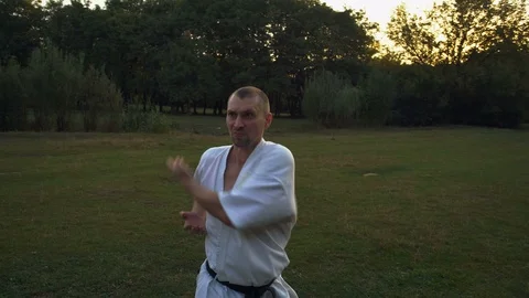 Guy in Kimono, Karate Practitioner, Trains at Glade in Rano City Park Morning Stock Footage 85488434