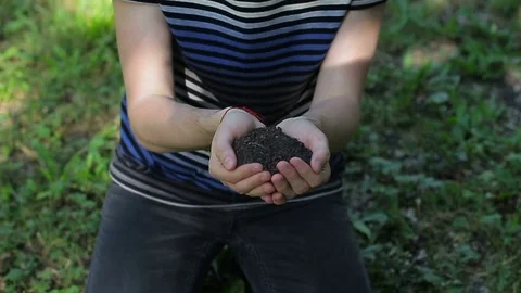 A guy kissing the soil in his hands Stock Footage