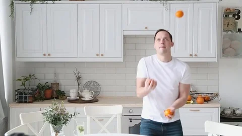The guy in the kitchen juggling oranges. At the end he drops Stock Footage 76091643
