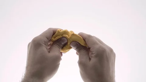 The guy kneads in hand modeling clay. white background Stock Footage 105861288
