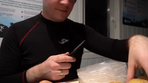 A guy with a knife in his hands peels potatoes Stock Footage 229930880