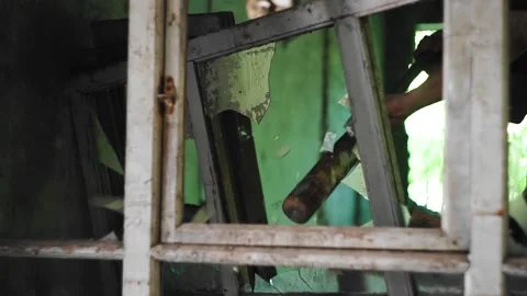 A guy knocks glass out of the frames of old Windows in an abandoned house Stock Footage 133541193