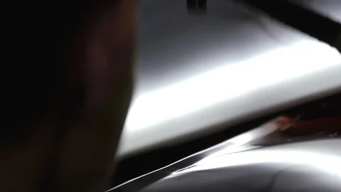 The guy knocks with a hammer on the car to align the dent on technology PDR Stock Footage 113109539