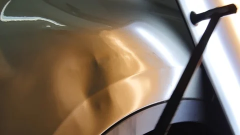 The guy knocks with a hammer on the car to align the dent on technology PDR Stock Footage 113110595