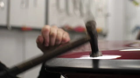 The guy knocks with a hammer on the car to align the dent on technology PDR. Stock Footage 151786573