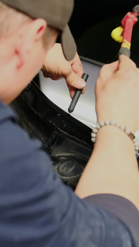 Guy knocks with slide hammer on knockdown tool to eliminate dent Stock Footage 316174335