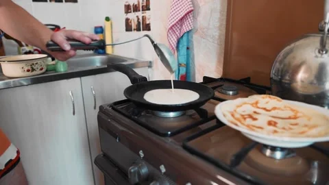 The guy with a ladle pour the batter onto a hot frying pan Stock Footage 134424441