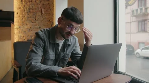 The guy with laptop is perplexed because of the mistake. A freelancer is Stock Footage 234495841