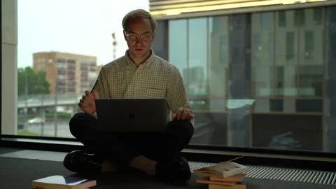 Guy with a laptop by the window Stock Footage 131511388