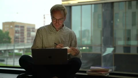 Guy with a laptop by the window Stock Footage 131511430