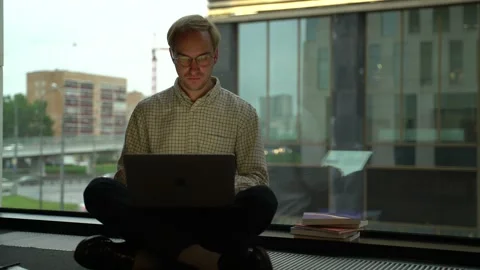 Guy with a laptop by the window Stock Footage 131511443
