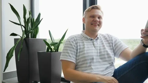 The guy laughs with the smartphone. A man is smiling while making selfies. A Stock Footage 81466536