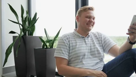 The guy laughs with the smartphone. A man is smiling while making selfies. A Stock Footage 81561757