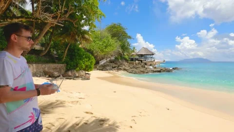 A guy launches a drone on a beach "Sunset beach" Stock Footage 155797633