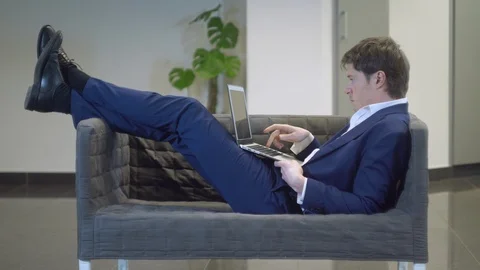 Guy laying in couch computing on pc Stock Footage 107657779