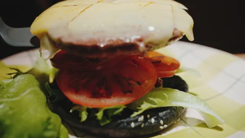 The guy lays a cutlet with his bare hands with cheese to make a burger Stock Footage 171487940
