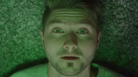 Guy Lays Down With Colors of Changing Lights On Face Stock-Footage 270310164