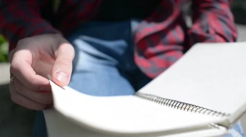 Guy Leafs net notebook sitting in park Stock Footage 64080818