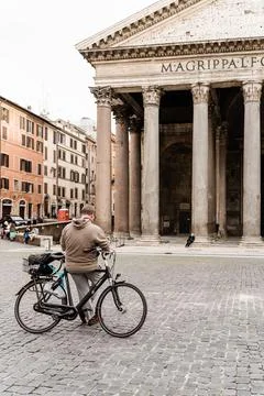 A guy leaning on a bicycle in an empty square in front of the Pantheon in Rom Stock Photos