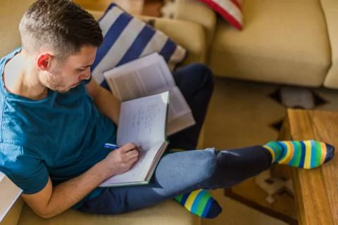 Guy learning at home while drawing on notes Foto stock