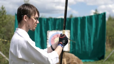 Guy learns to shoot a bow Stock Footage 104030465
