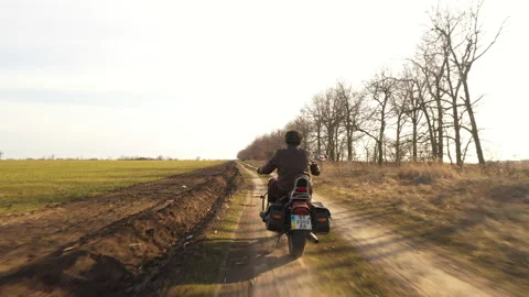 Guy in leather jacket riding off-road countryside on chopper in autumn sunny day Video stock 151970252