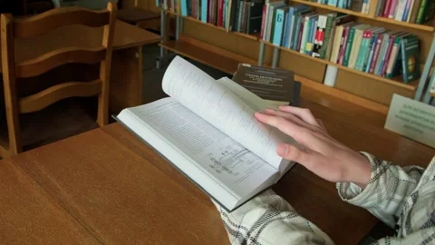 Guy in the library reading a book Stockbeeldmateriaal 253188460