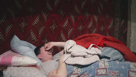The guy lies in bed and laughs Stock Footage 231711528