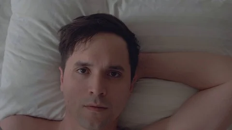 The guy lies down and enjoys it. Pathetically. Close up. Smile. Satisfaction Stock Footage 100706679