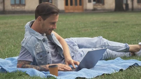Guy lies on the lawn on campus Stock-Footage 79675963
