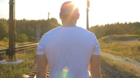 The guy in the light of the sunset walks on the railroad. Stock Footage 162236352