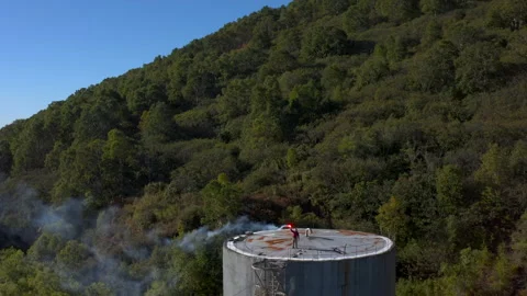 The guy lights a signal light while on a high water-pressure tower Stock Footage 143069894