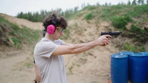 Guy load handgun, aim and shoot target during instructor supervision, 動画素材 275833974