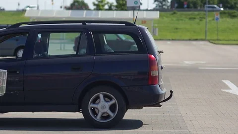 The guy loads the purchases in the trunk of the car at parking lot. The role of Stock Footage 78024752