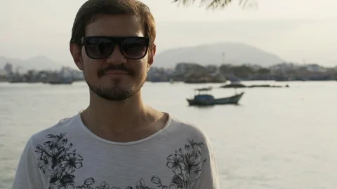 Guy look into camera and take off glasses at sunset rapid slow motion Stock Footage 88710325