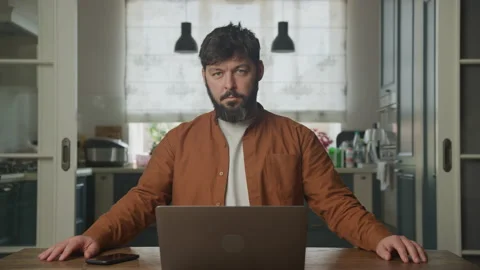 Guy looking at camera and waiting in front his laptop Stockbeeldmateriaal 196215436