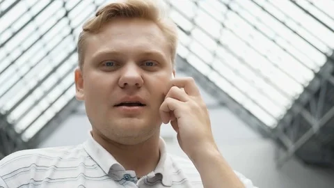 Guy is looking at the camera, smiling and talking on the phone. Happy Young Man Stock Footage 81563682